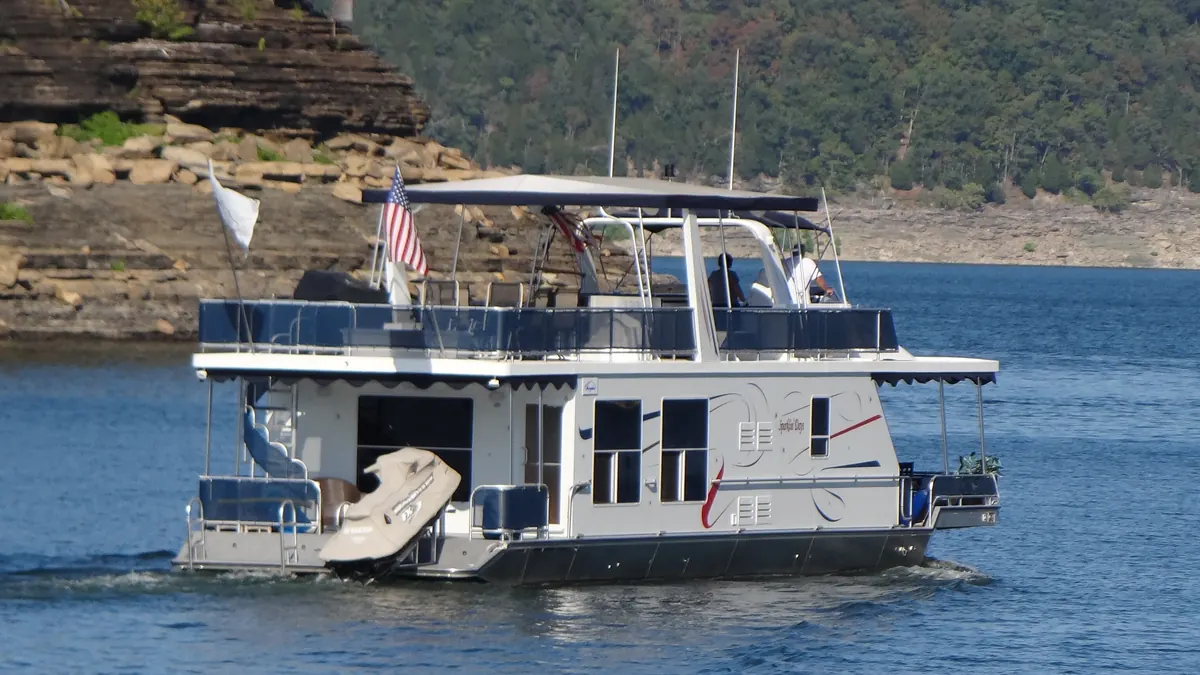 Houseboat cruising past limestone bluffs on Lake Cumberland, Kentucky